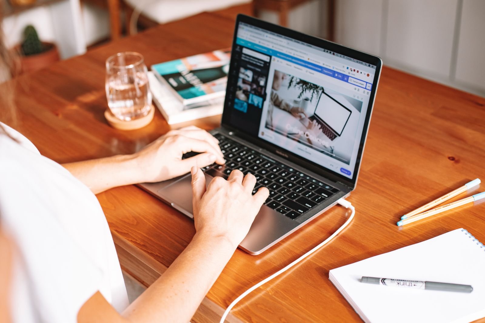 Person working on a laptop at a wooden home office desk